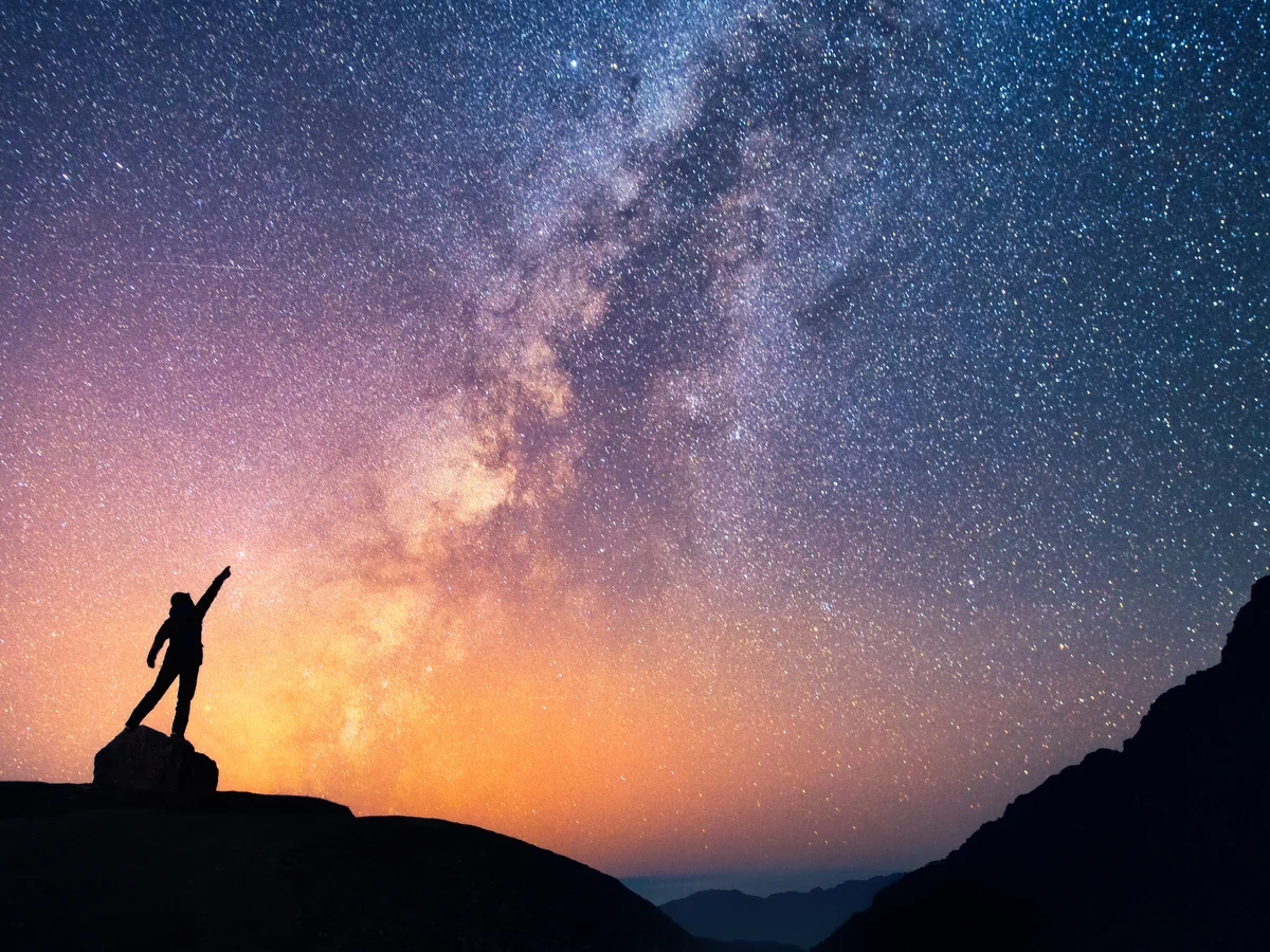 A person standing beneath a star-filled sky